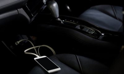 Ładowarka samochodowa do telefonu ładuje smartfon na siedzeniu kierowcy.